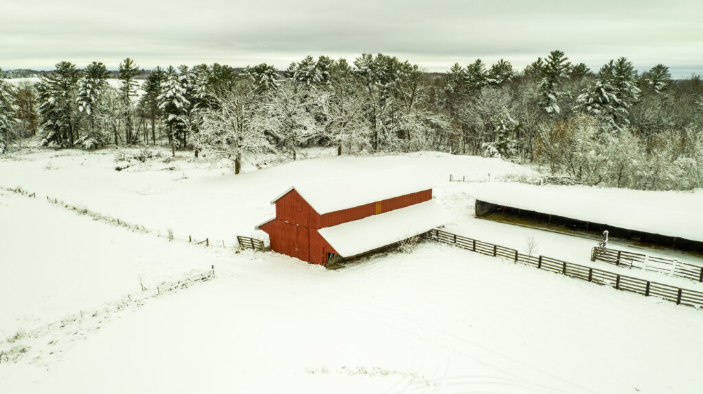 beautiful aerial phot of red stable in bright white snow